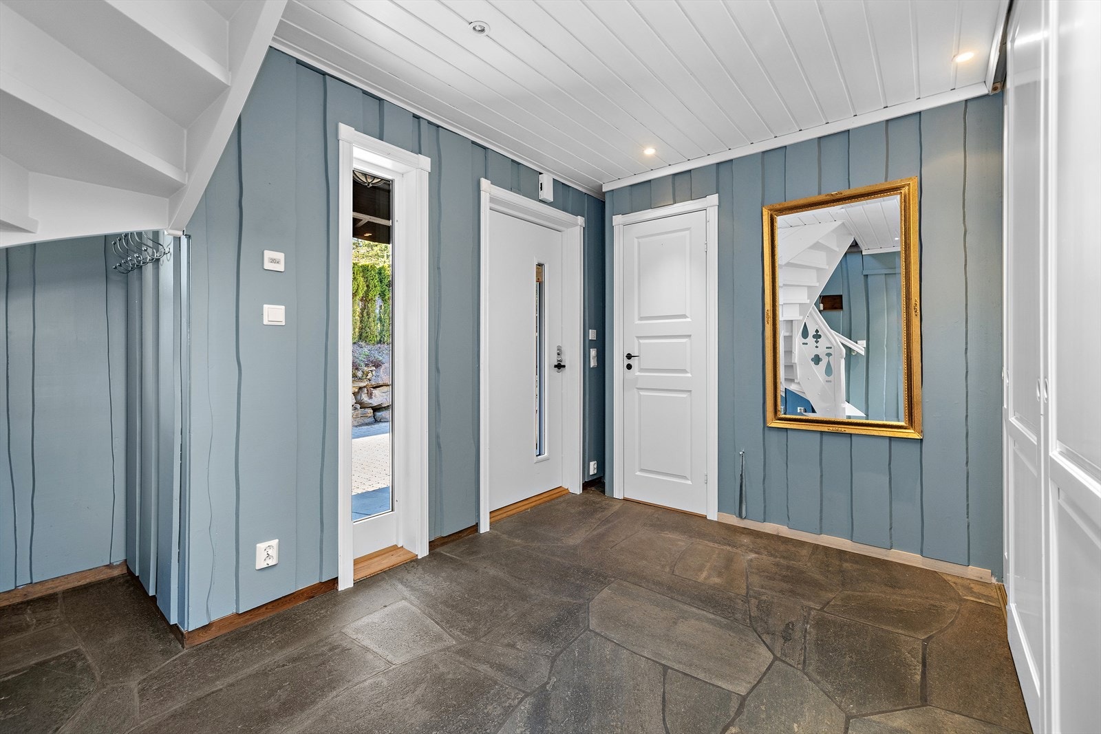 Den nye hovedytterdøren er utstyrt med smartlås. Fra hallen er det direkte tilgang til den åpne stue- og kjøkkenløsningen. Praktisk gjestetoalett i hallen. Galleribilde