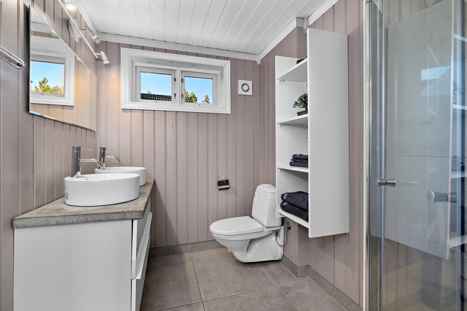 Badet i loftsetasjen ble pusset opp i 2021 med nye fliser, varmekabler i gulvet og servantinnredning med doble servanter. Galleribilde