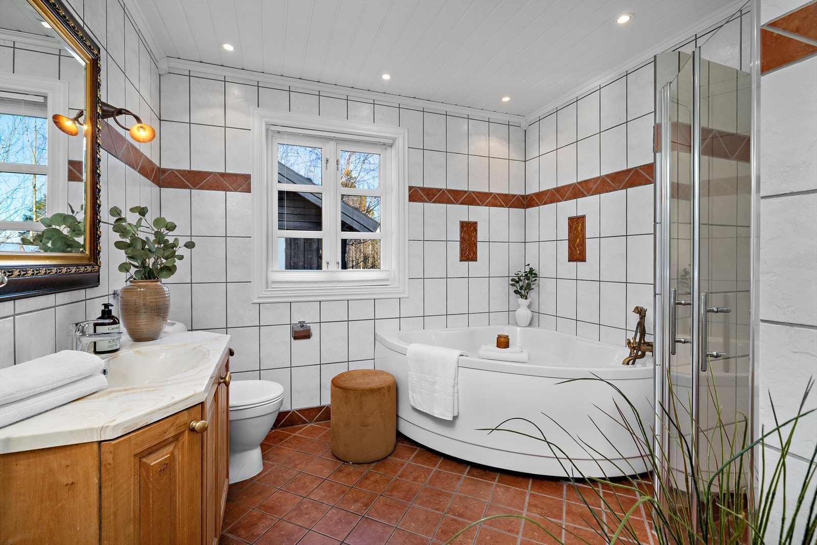 Badet er utstyrt med både dusjhjørne og hjørnebadekar, og er tilkoblet boligens balanserte ventilasjonsanlegg. Galleribilde