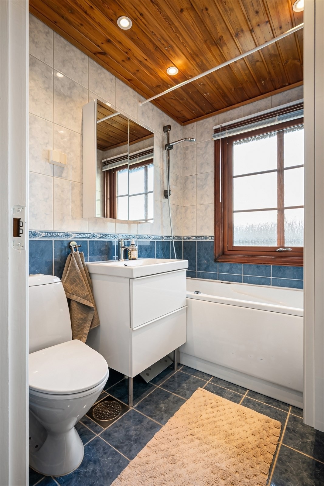 Bad med adkomst fra gang - rett ved boligens tre soverom. Nye spotter i tak i bad og gang i 2026. Badet består av flislagte overflater med dusjløsning/badekar. Galleribilde