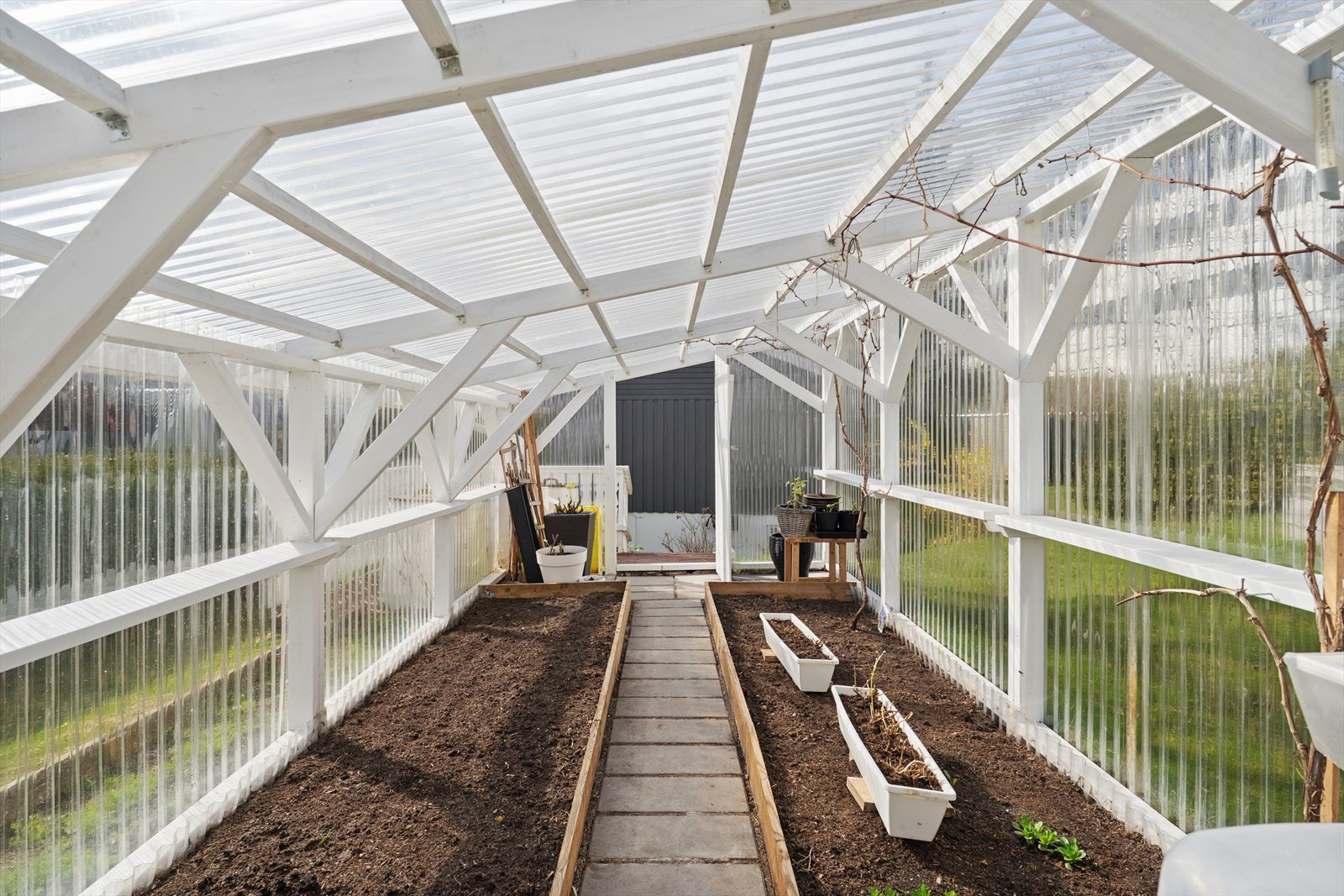 Inne i drivhuset er det klargjort med plantekasser for dyrking av egne grønnsaker og urter. Galleribilde