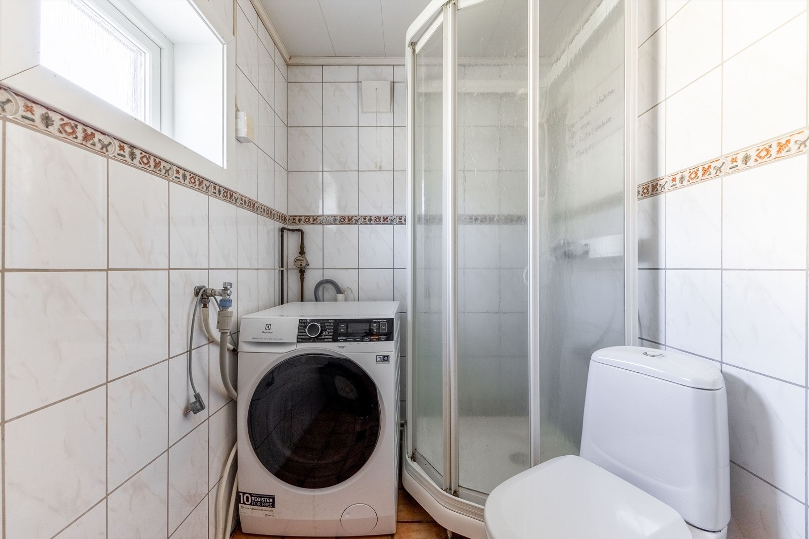Badet er utstyrt med servantinnredning, WC, dusjkabinett samt opplegg for vaskemaskin. Galleribilde