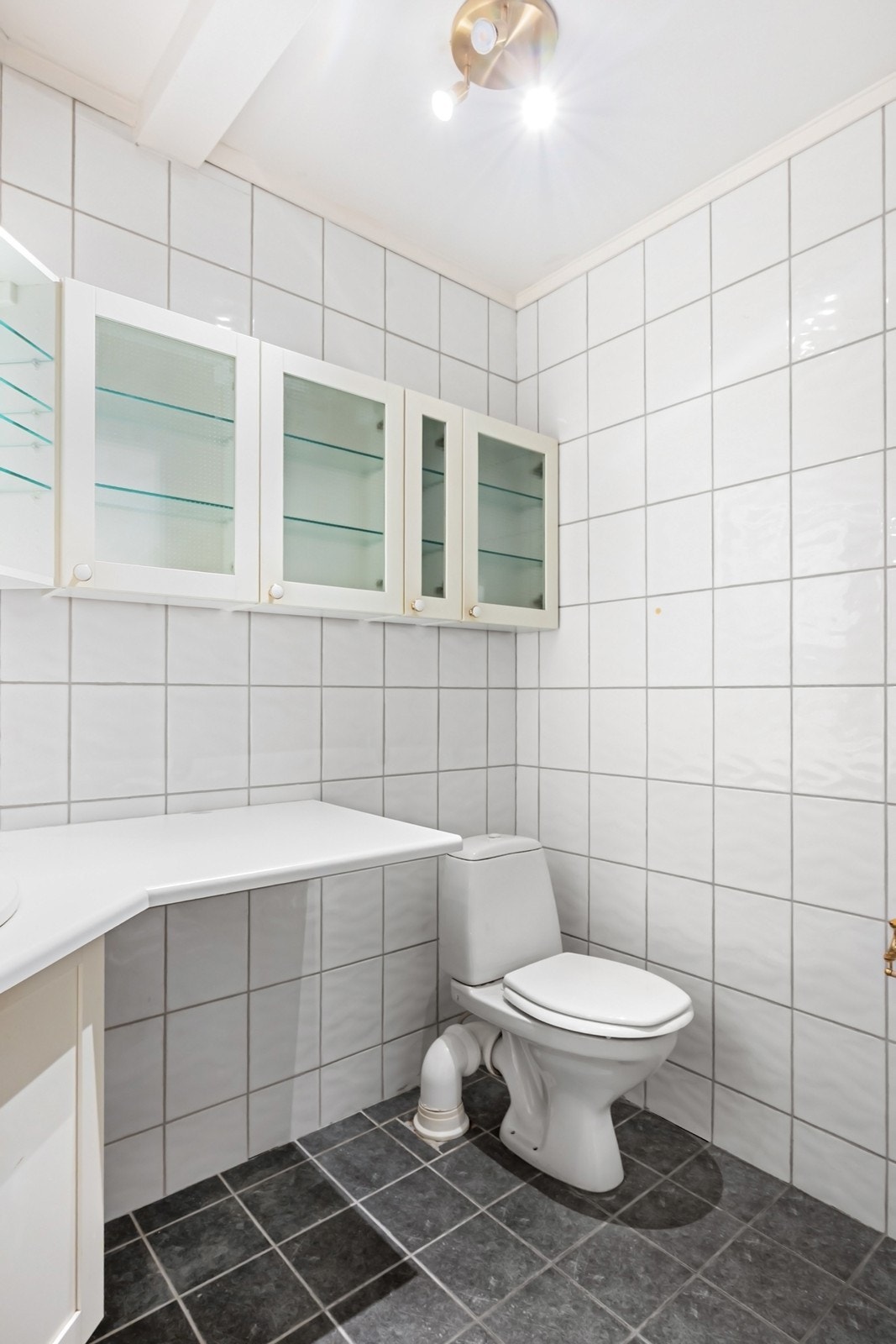 Badet har adkomst fra entreen, med flislagte overflater og behagelig gulvvarme. Galleribilde