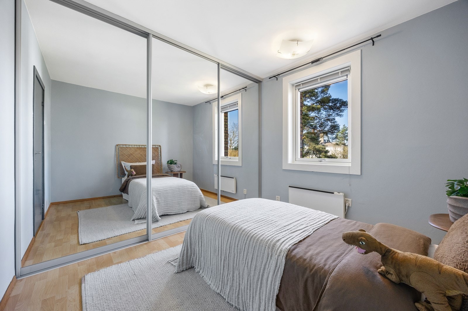 En stor skyvedørsgarderobe med speilfronter gir rikelig med oppbevaringsplass. Galleribilde