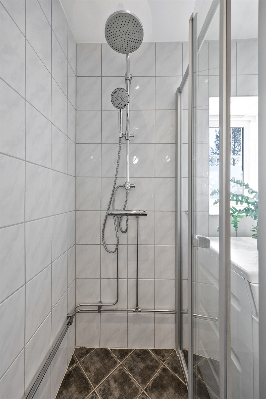 Dusjhjørnet på badet har innfellbare dører som frigjør gulvplass når dusjen ikke er i bruk. Galleribilde