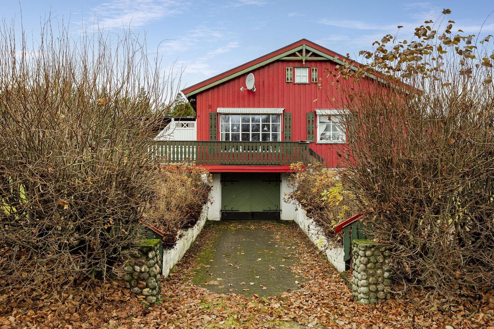 Huset har innkjørsel med steinbelagt dekke frem til garasjen i kjelleren. Galleribilde