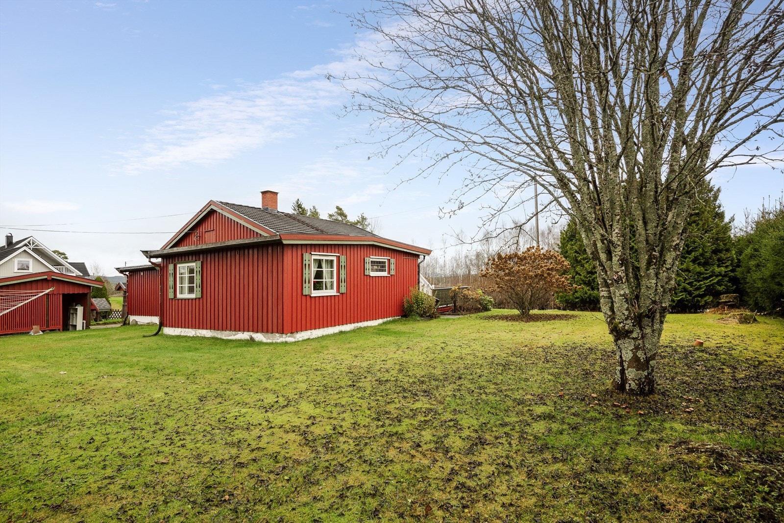 Tomten er på ca. 1 622,1 m², har plen og beplantning med busker, trær og blomster. Galleribilde
