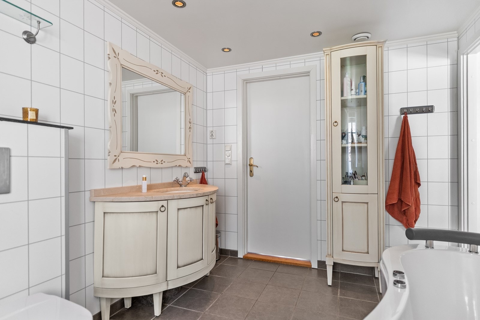 Badet inneholder stort badekar, vegghengt toalett, dusjkabinett, servant med skap, samt opplegg for vaskemaskin. Galleribilde