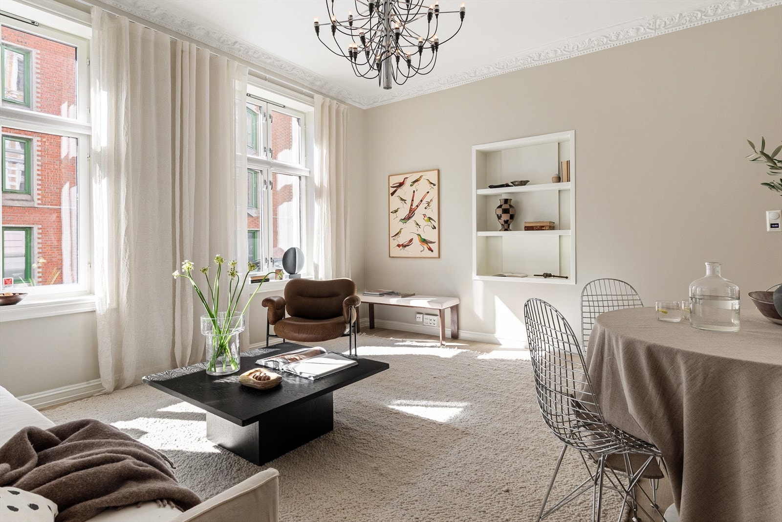 Stuen rommer stor sofa, spisebord, og har innfelt nisje i vegg. Galleribilde