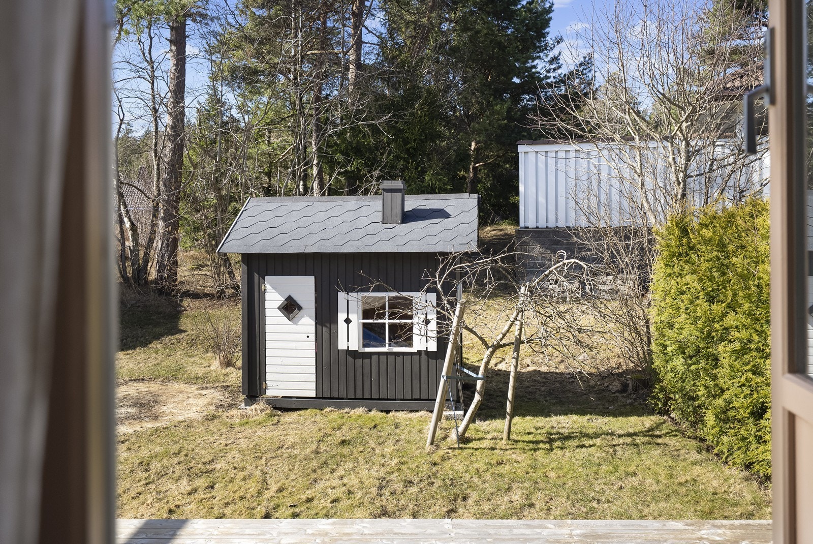 Utsikt fra terrassen mot hagen. Her er det også oppført en lekestue/uthus. Galleribilde