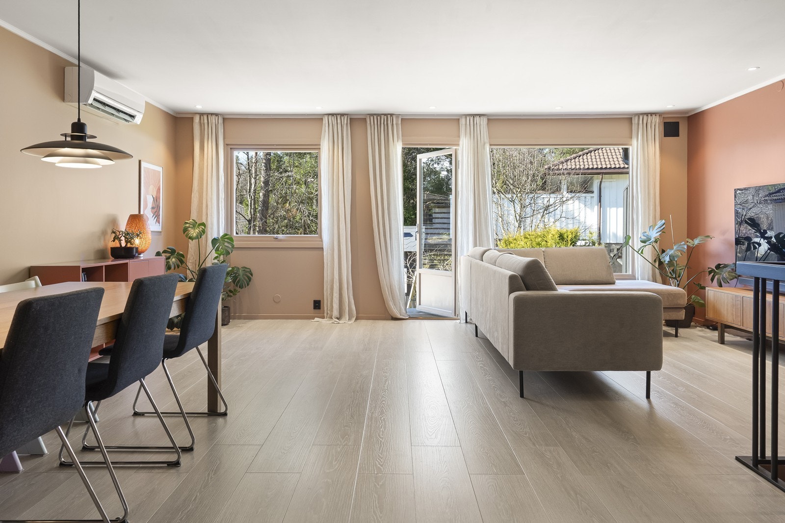 Fra stuen er det direkte utgang til en romslig terrasse på terrengnivå. Videre er det downlights i himlingen og en luft-til-luft varmepumpe installert i 2021 for effektiv oppvarming. Galleribilde