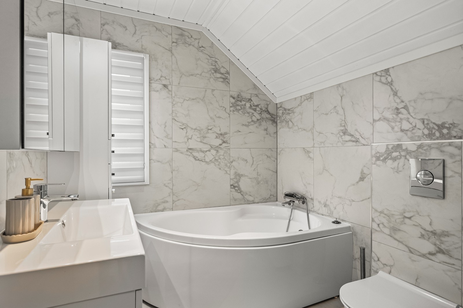 Badet i 2. etasje har flislagte overflater og er utstyrt med badekar og vegghengt toalett. Galleribilde