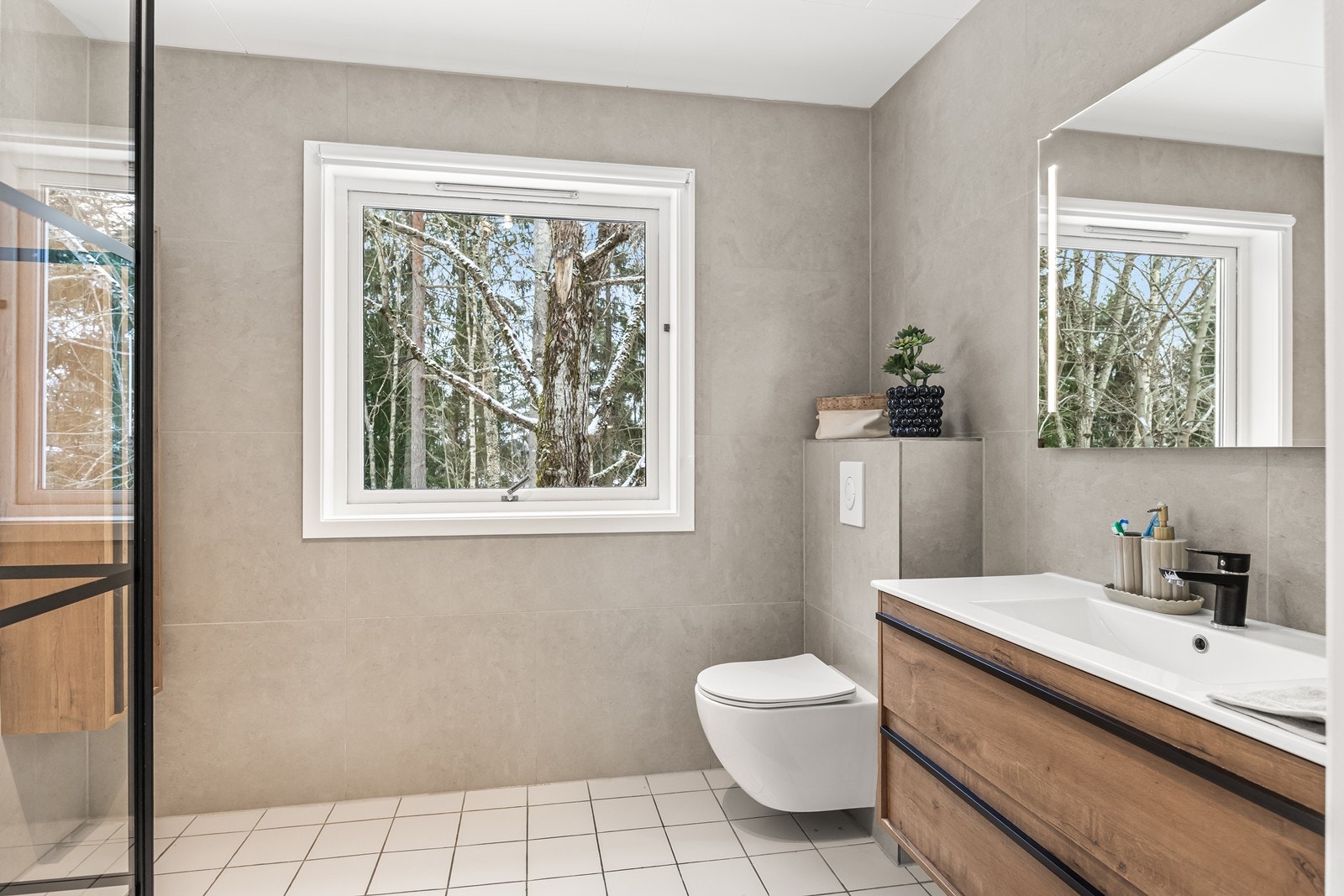 Badet i 1. etasje har flislagte vegger og gulv, og er overflateoppusset i 2026. Galleribilde