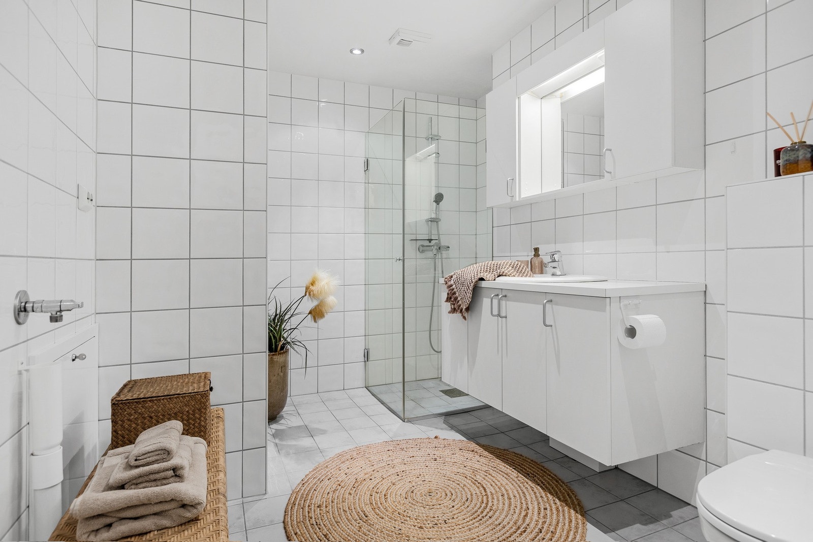 Innredning med vask, overskap med speil og skapløsning. Downlights i tak. Galleribilde
