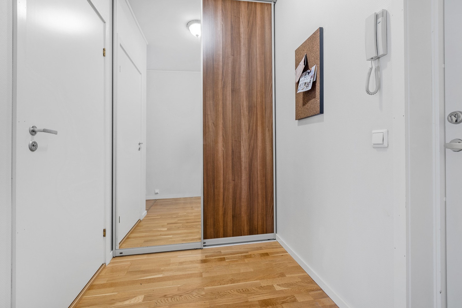 Skyvedørs garderobe i gang, porttelefon for inngangsdør på vegg. Galleribilde