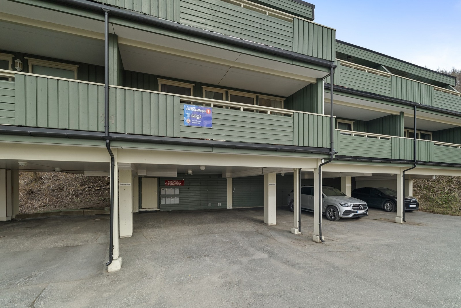 Parkering på asfaltert parkeringsplass i carport, hvor det er klargjort for el-billader Galleribilde