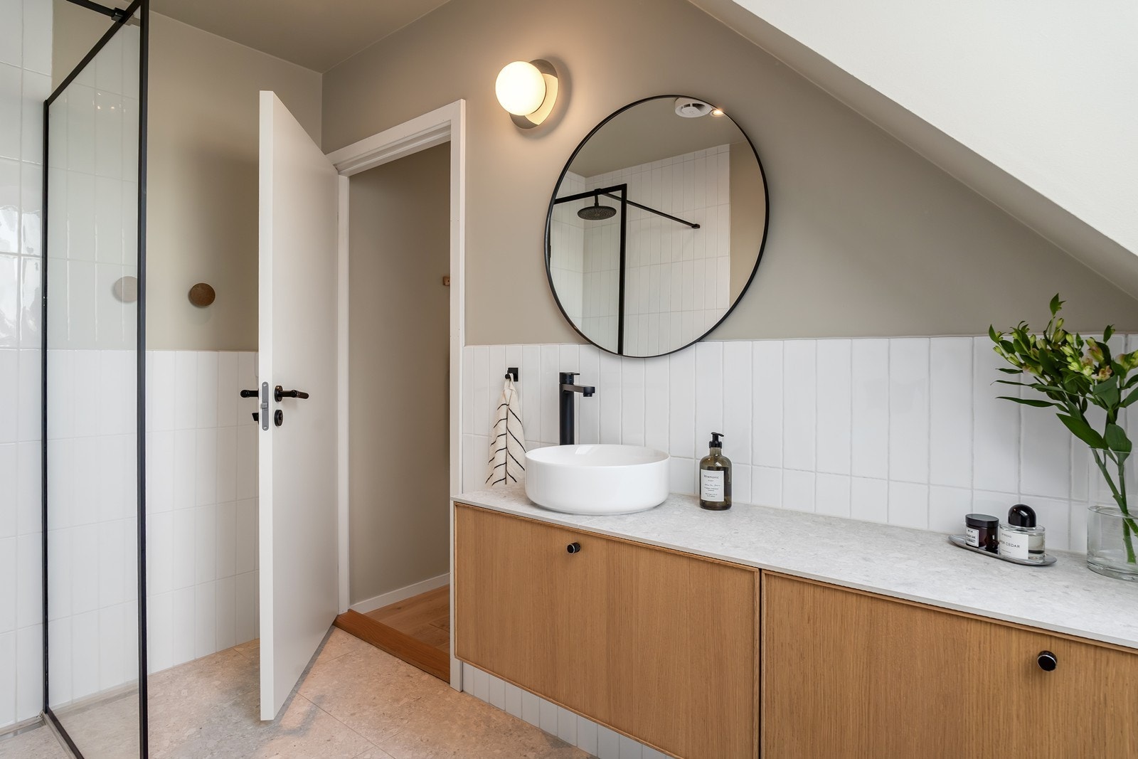 Badet er utstyrt med servant i møblement, speil med belysning, vegghengt toalett og dusjhjørne. Galleribilde
