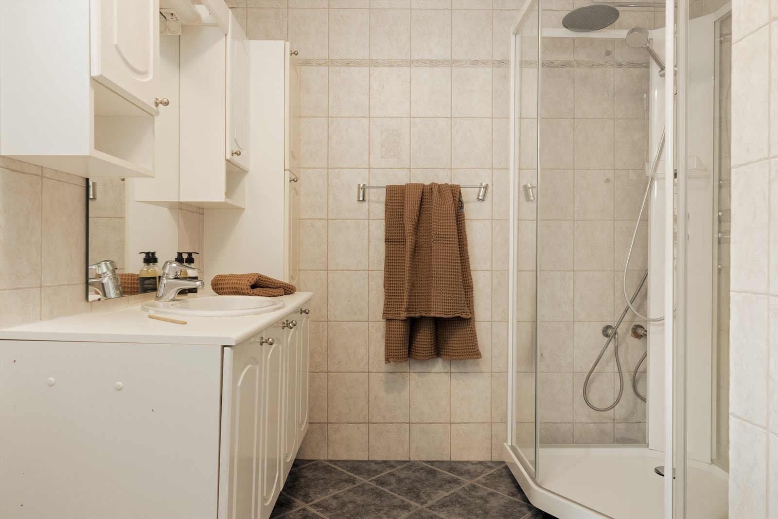 Badet i underetasjen inneholder baderomsinnredning med servant, toalett og dusjkabinett Galleribilde