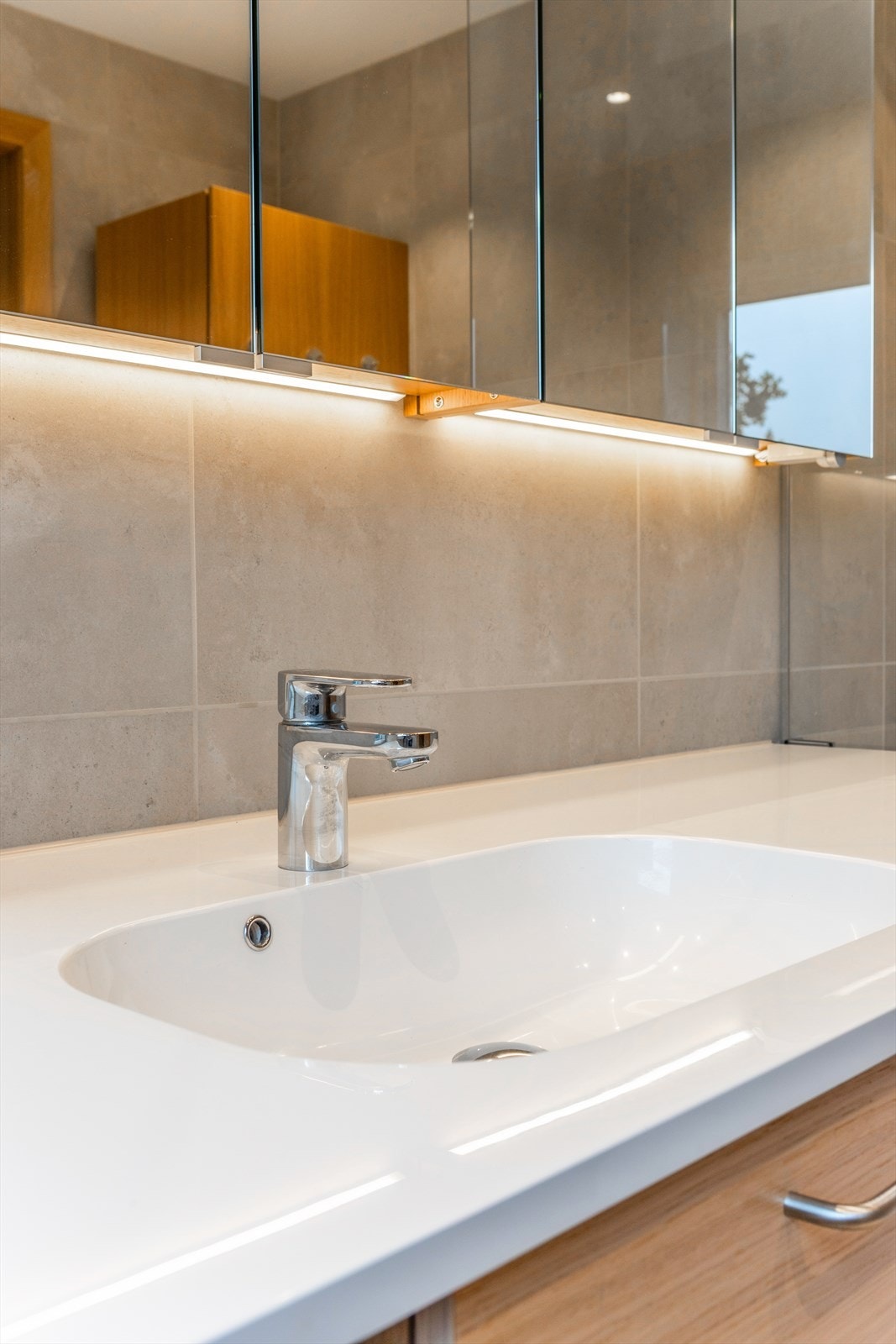Begge badene har store fliser på gulv og vegger, samt gulvvarme og innfelte downlights. Galleribilde