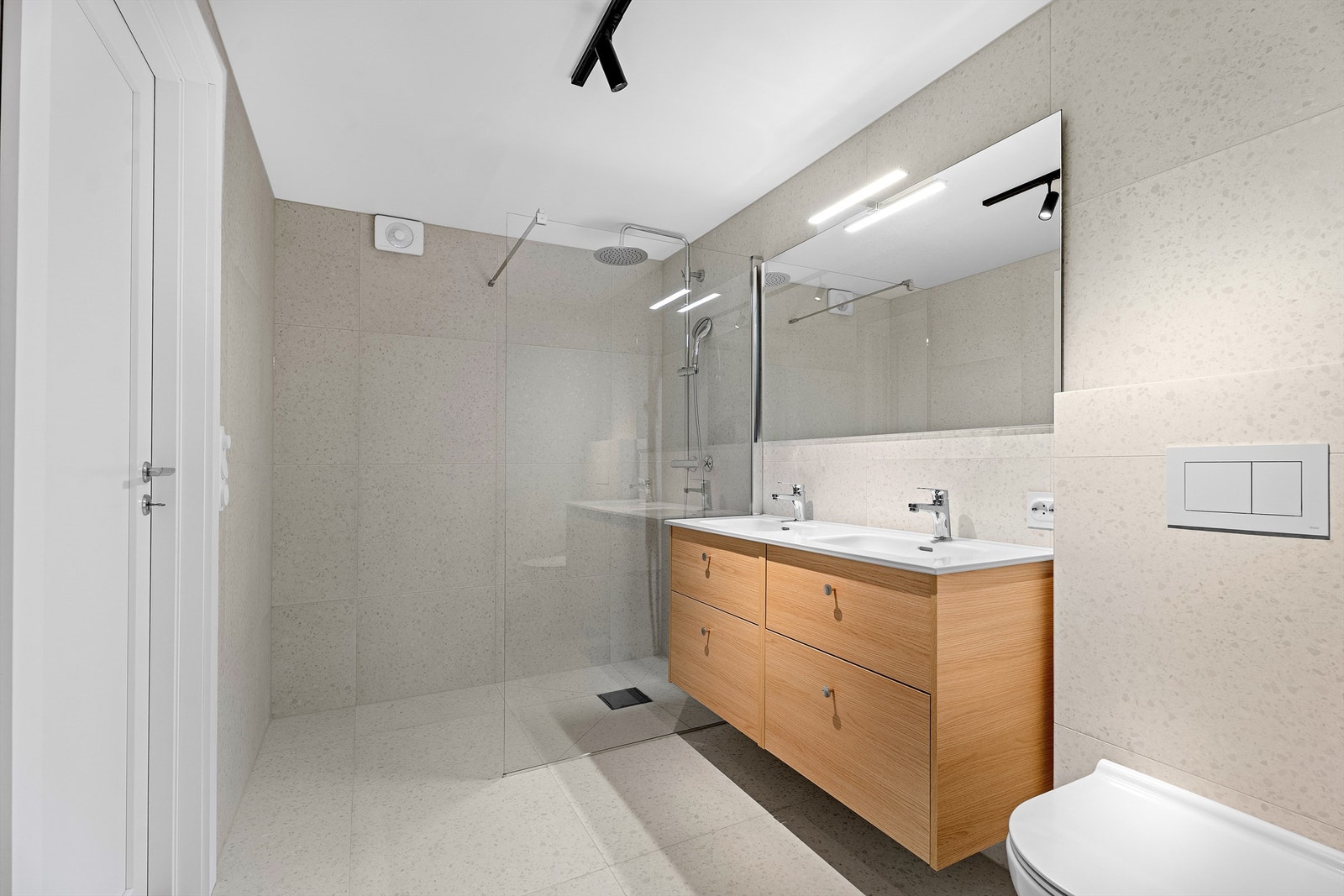 Badet i underetasjen med stor dusj, dobbel servant og baderomsinnredning fra Foss Bad Galleribilde