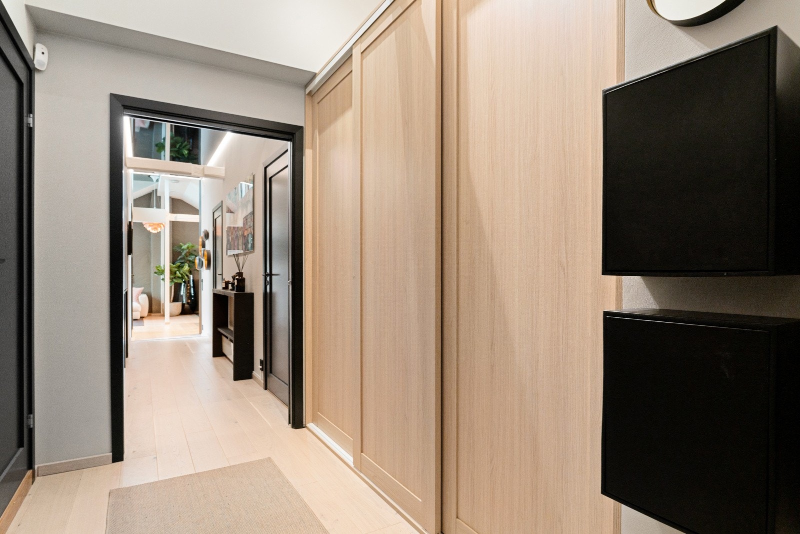 Entréen er lys og hyggelig med stor skyvedørsgarderobe for oppbevaring av sko og yttertøy. Skyvedøren til stuen kan både holdes åpen og lukket - alt etter ønske Galleribilde
