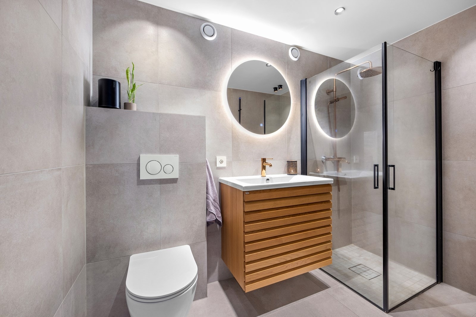 Badet har elektriske varmekabler i gulv og lys i tak, samt speil Galleribilde