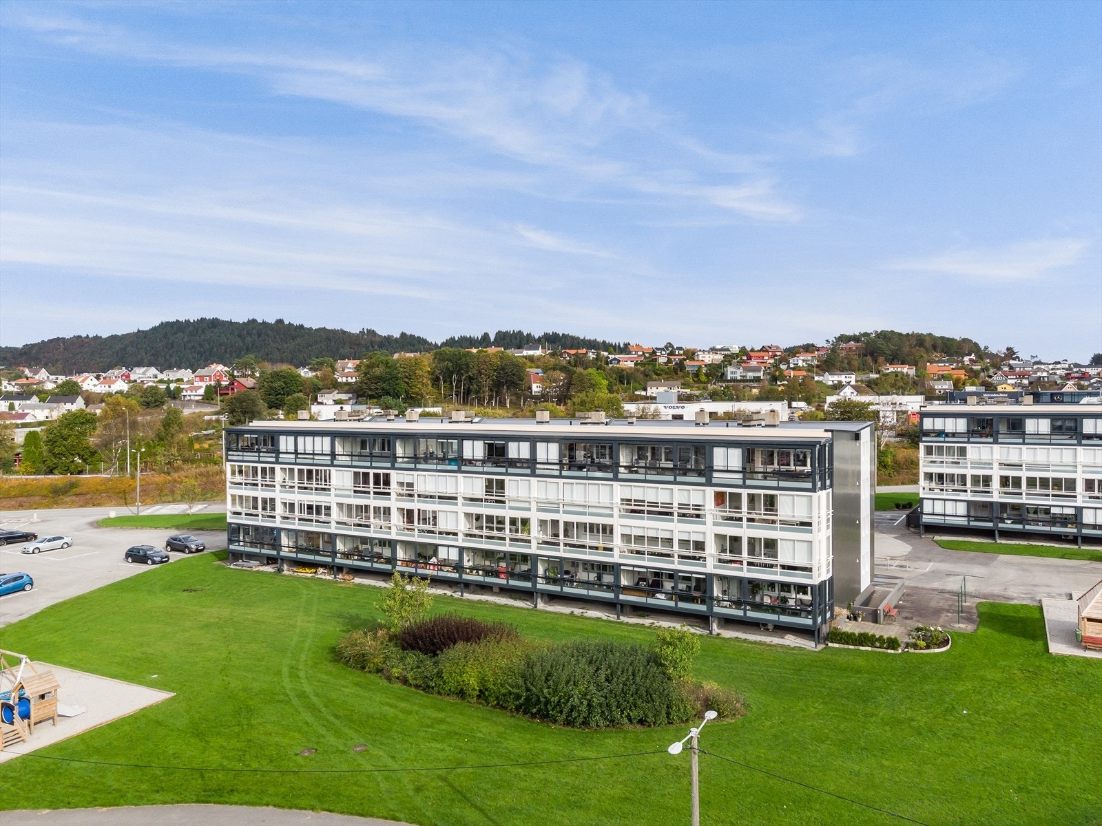 Eiendommen er opparbeidet med plen, beplantning og felles parkeringsplass Galleribilde