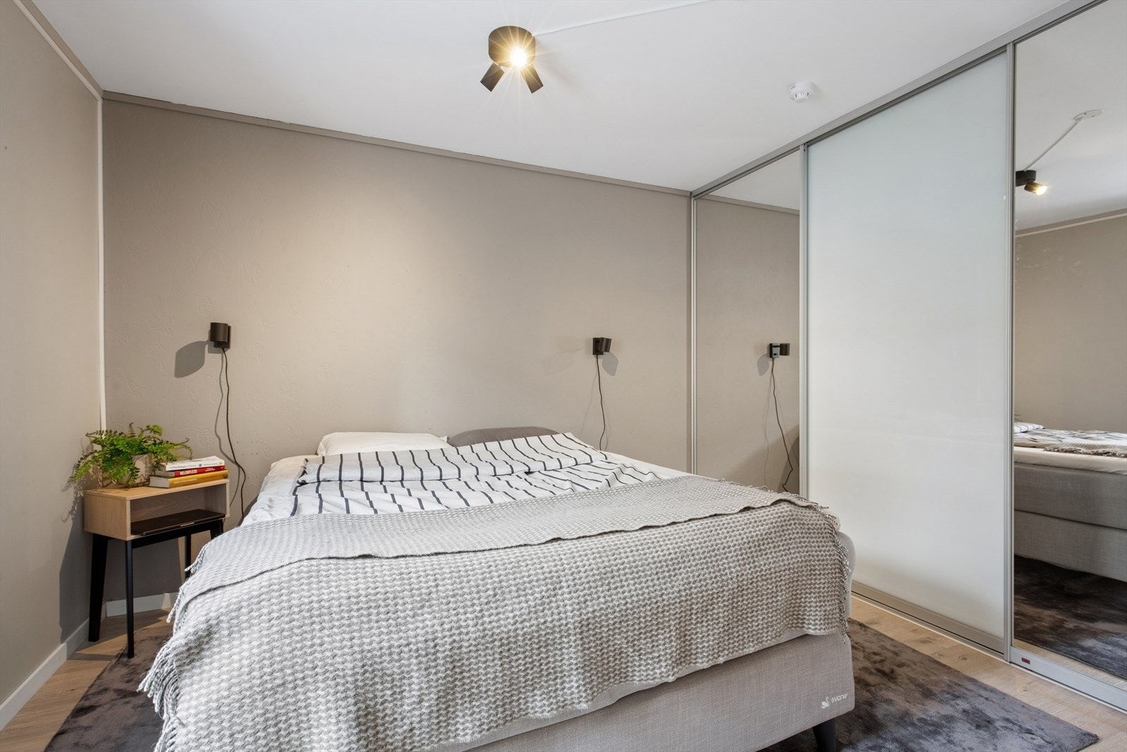 En stor skyvedørsgarderobe med speilfronter gir rikelig med oppbevaringsplass. Galleribilde