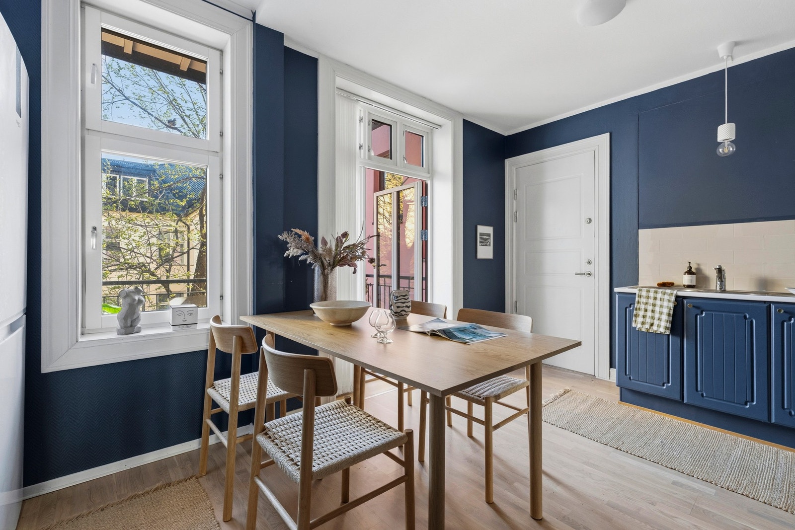 Kjøkkeninnredning med malte profilerte fronter, lys laminat benkeplate med nedfelt dobbel stålkum samt både fliser og backsplash plate på vegg Galleribilde