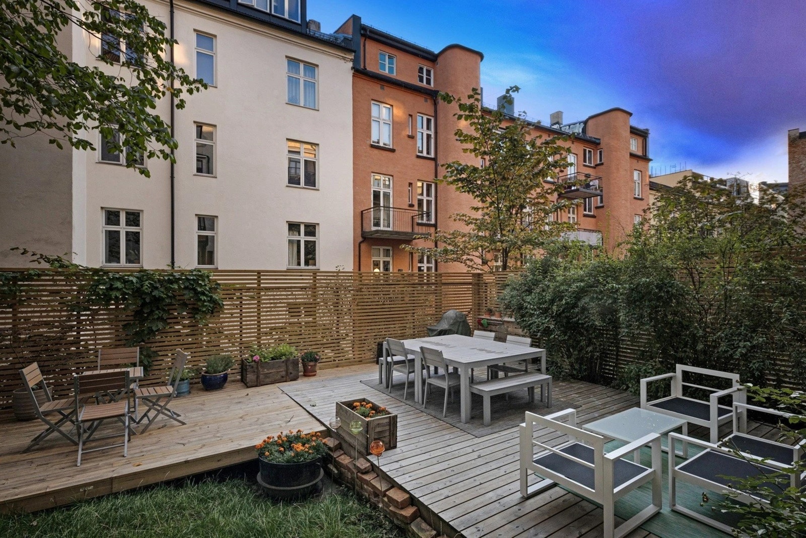 Bakgården er pusset opp i 2019 og er opparbeidet med en flott platting med sittegrupper, gressplen og beplantning Galleribilde