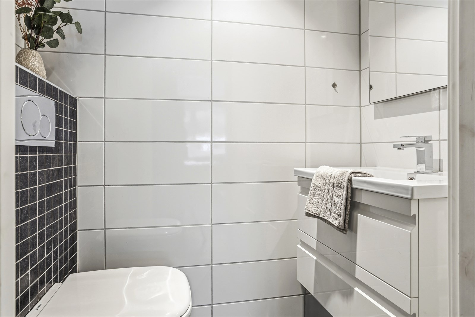 Toalettrom med vegghengt toalett og servant. Galleribilde