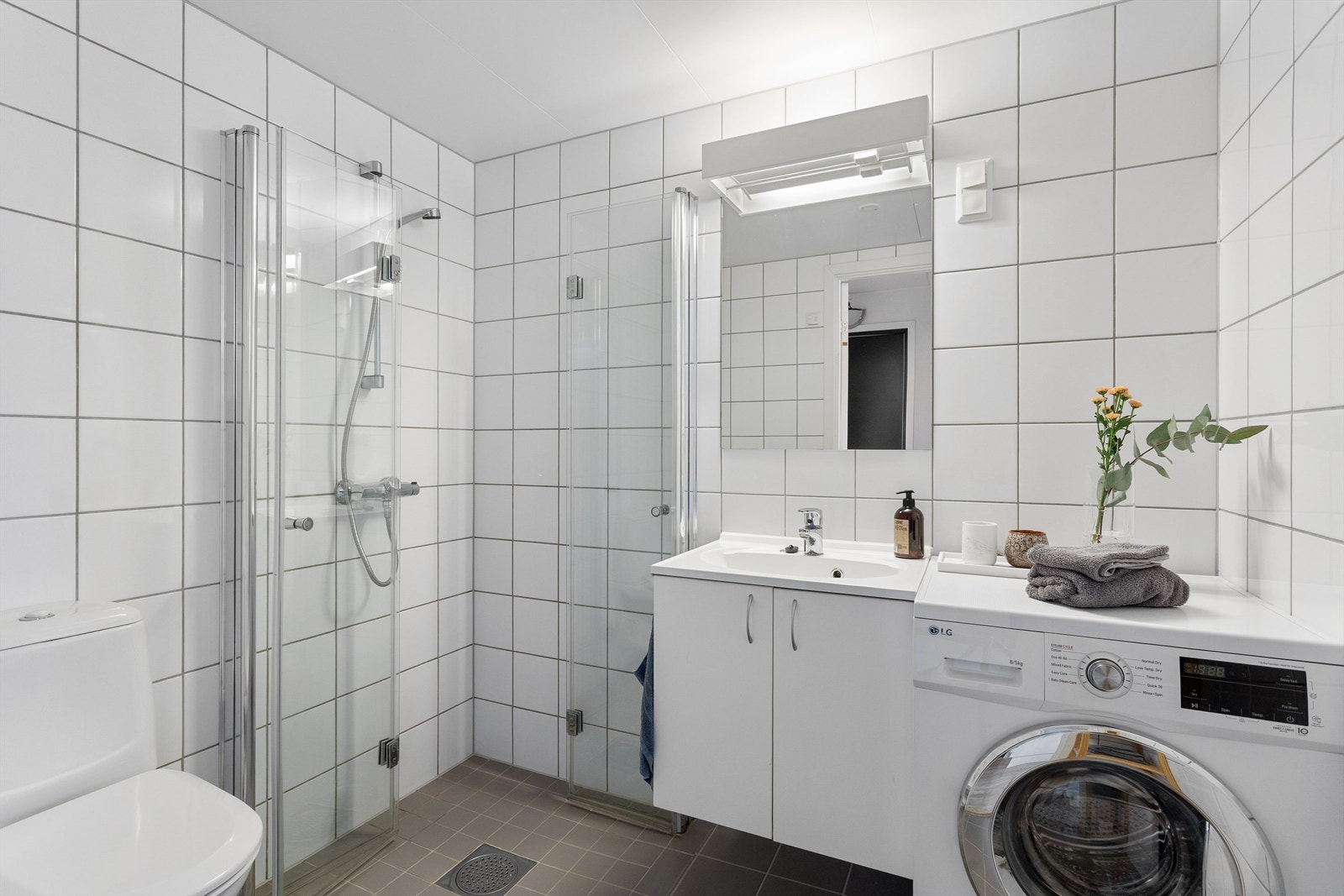 Flislagt bad med elektrisk gulvvarme for økt komfort. Det er opplegg for vaskemaskin. Galleribilde