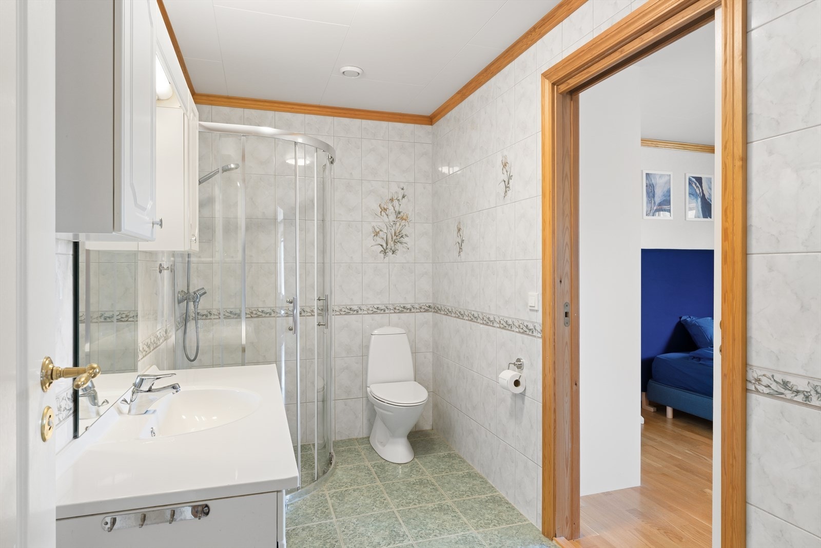 Badet er helfliset og inneholder wc, dusjhjørne og servant i seksjon. Galleribilde