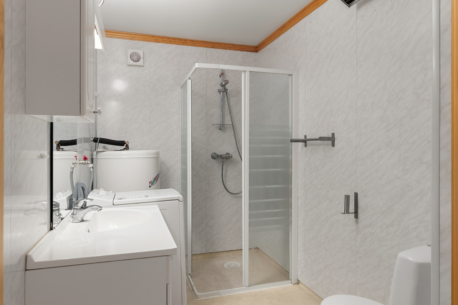 Bad innredet med dusj, toalett, vask i seksjon og med opplegg for vaskemaskin. Galleribilde