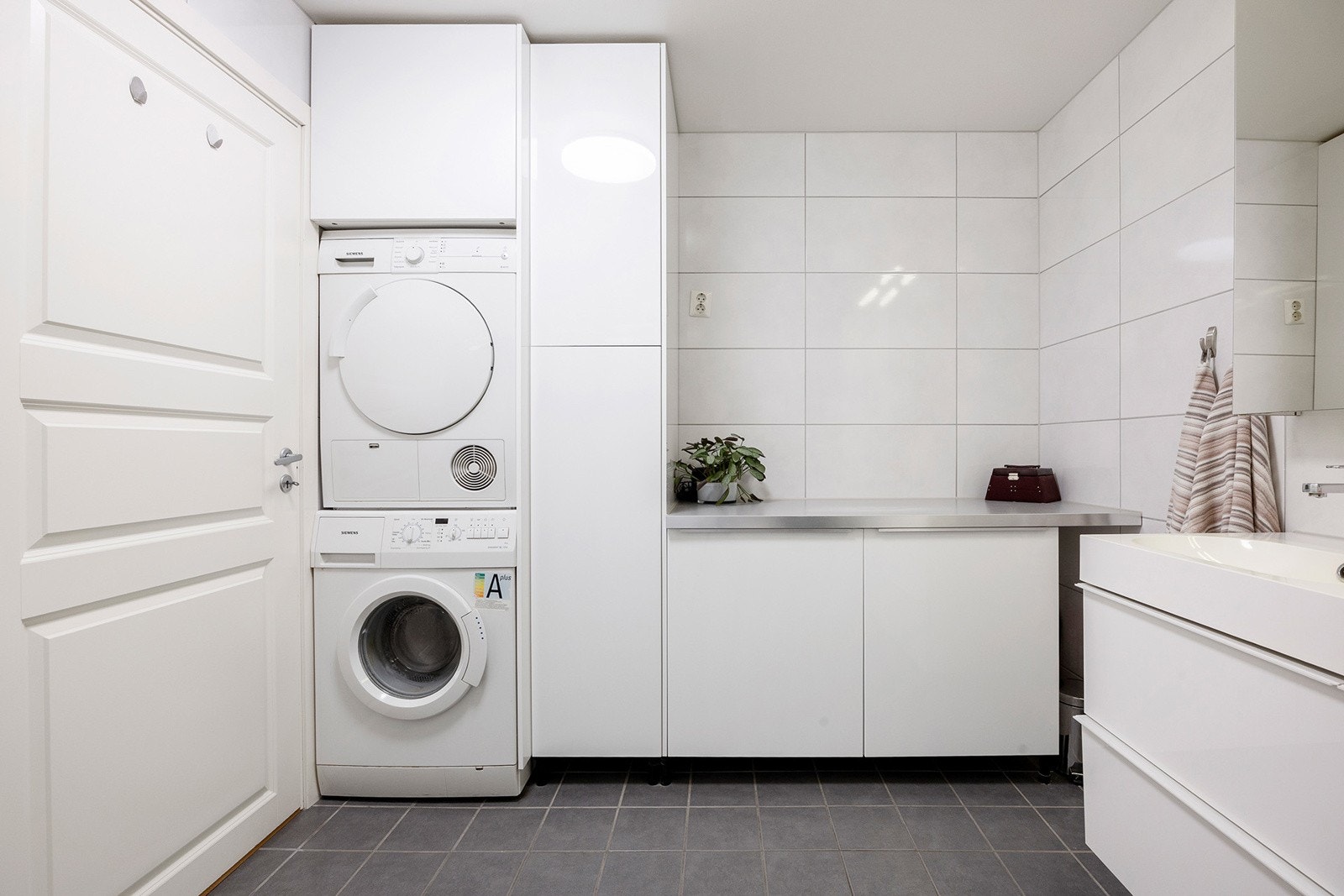 Badet har opplegg for vaskemaskin, veggmontert skap med god oppbevaringsplass samt funksjonell baderomsinnredning med laminert benkeplate og høyskap. Praktisk og brukervennlig løsning. Galleribilde