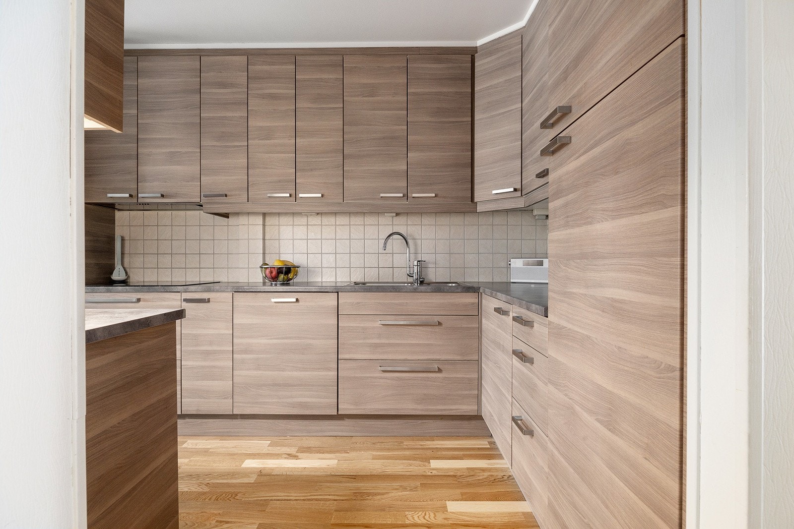 IKEA-innredning fra 2013 med glatte, folierte fronter og laminert benkeplate med dobbel stålkum. Galleribilde