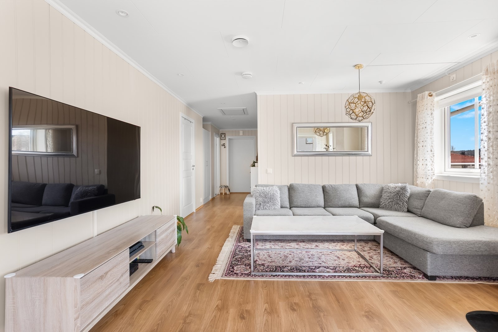 Stuen er romslig og lett å møblere, med plass til både sofagruppe og TV-seksjon. Galleribilde
