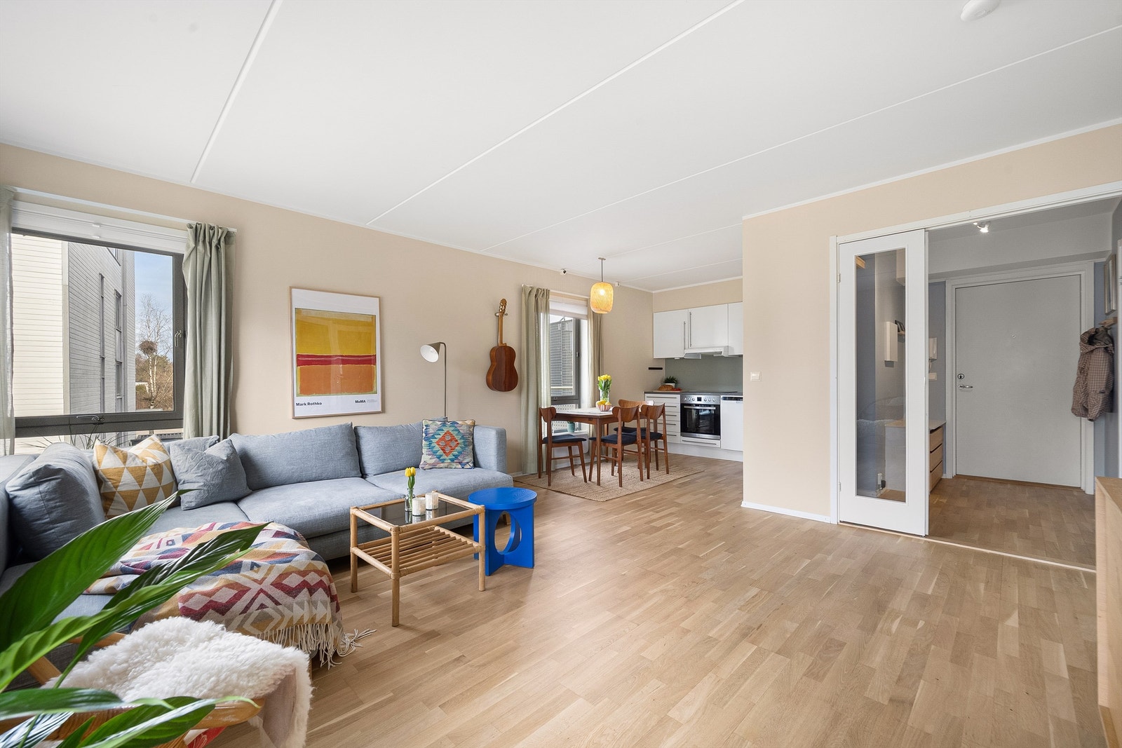 Den delvis åpne løsningen mellom stue og kjøkken skaper en sosial og luftig sone, perfekt for samvær med familie og venner. Galleribilde