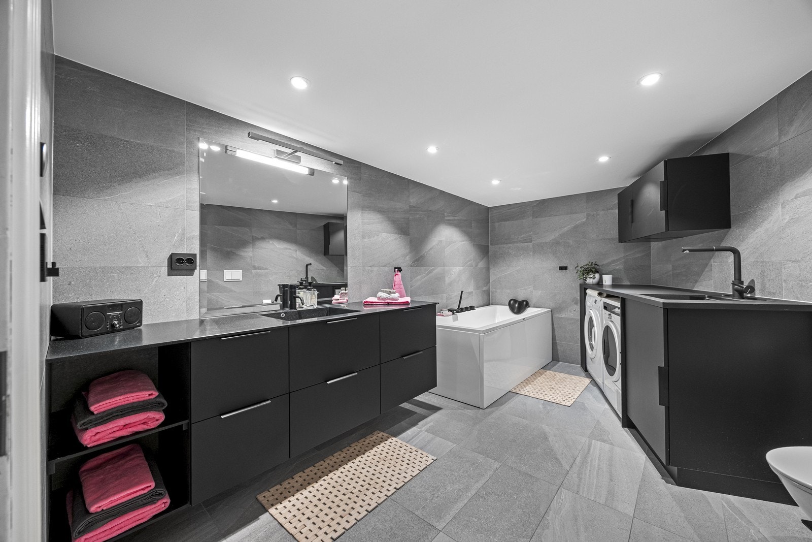 Badet ble renovert i 2019 av firma, og har flislagte overflater og varmekabler i gulv. Badet er innredet med badekar, stor baderomsinnredning med speil, innredning og skap til vaskemaskin og tørketrommel, samt vask. Galleribilde