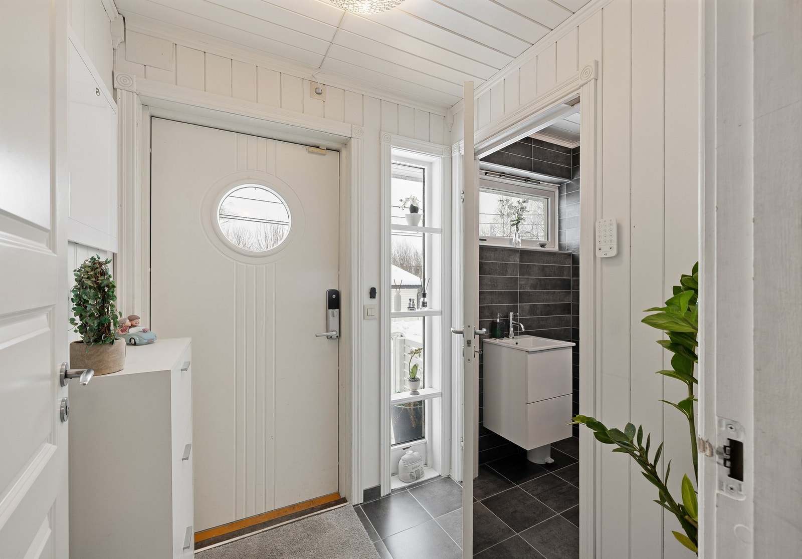 Innbydende flislagt entrè med direkte adkomst til toalettrom og mellomgang. Galleribilde
