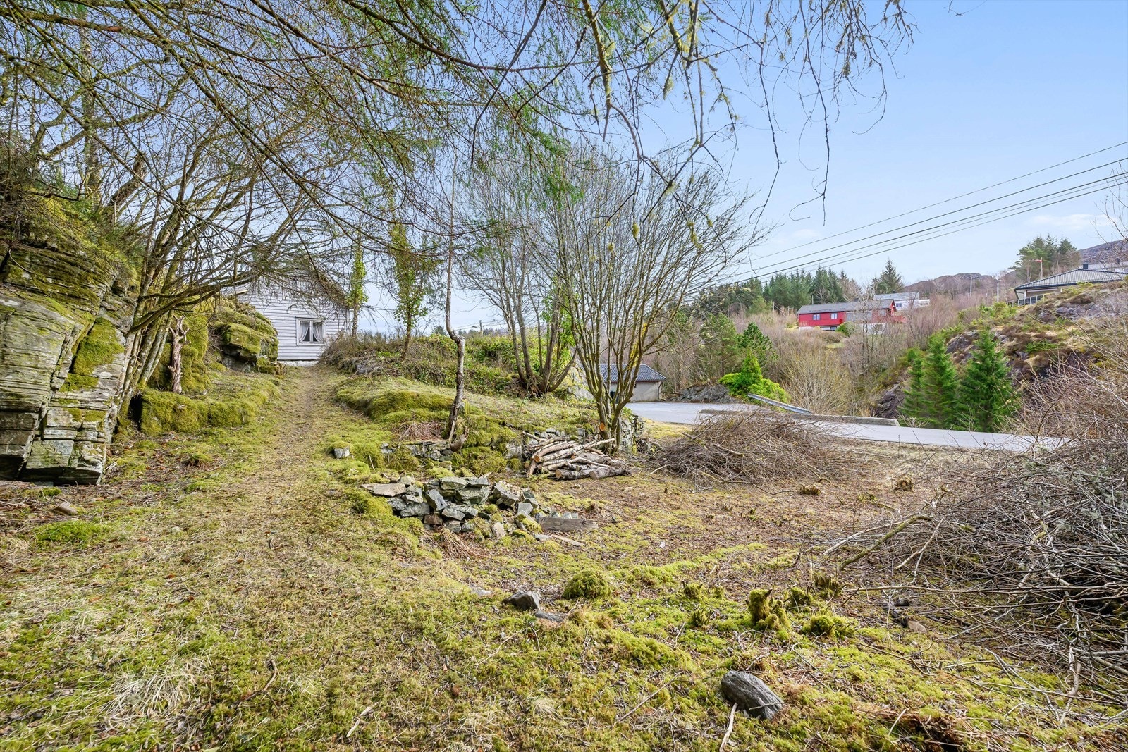 En ser flere gangveier/kjerreveier og grunnmurer ved boligen. Galleribilde