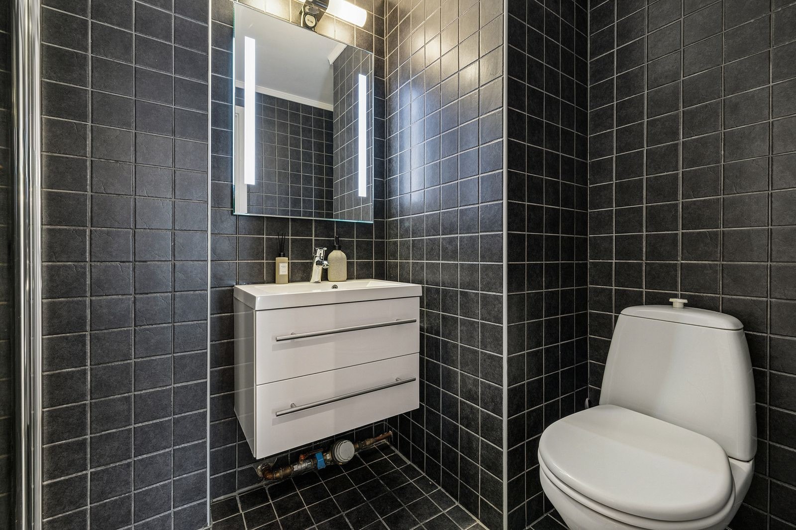 Badet har flislagte gulv og vegger samt malt himling. Gulvet er utstyrt med elektriske varmekabler. Galleribilde