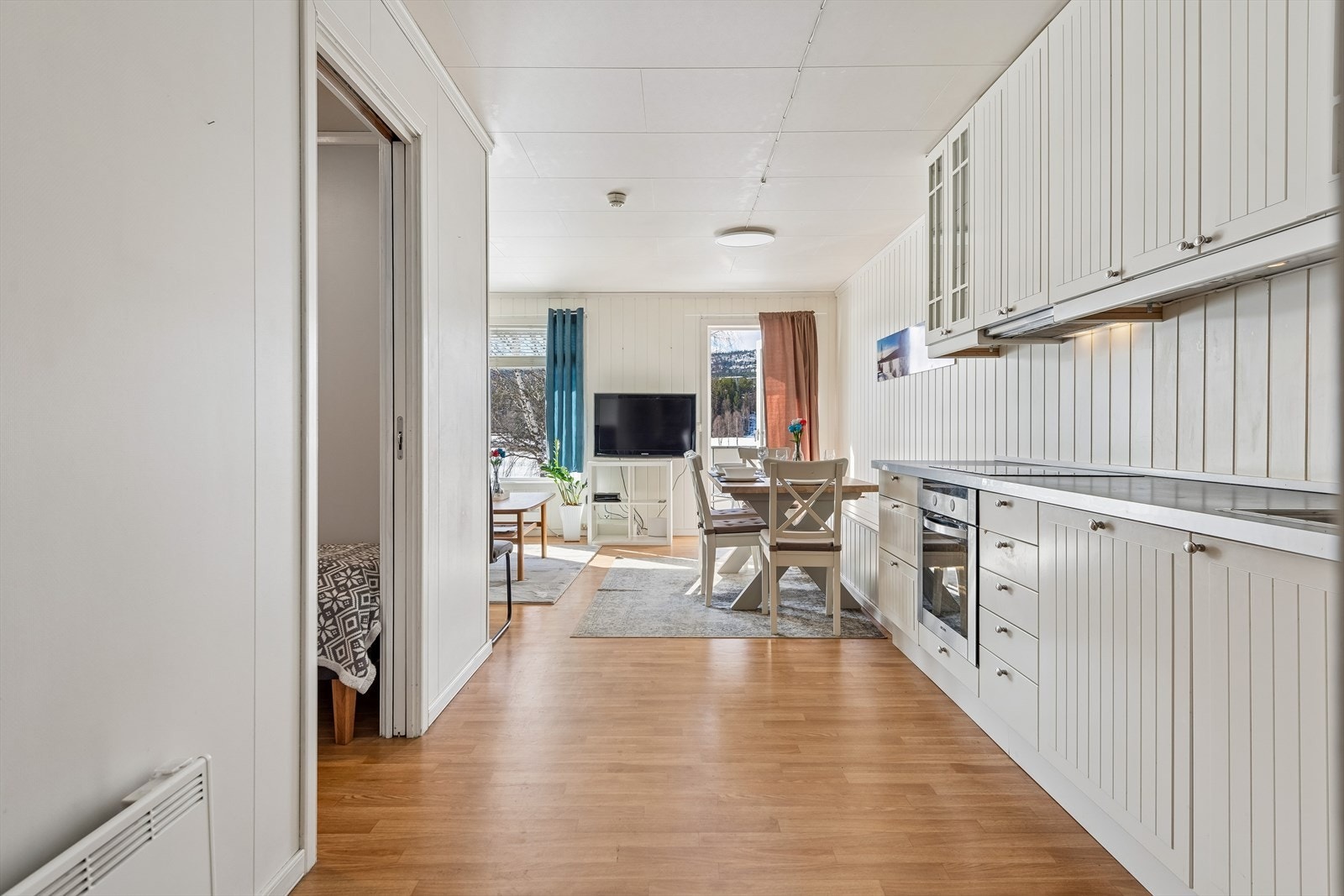 Den åpne løsningen mellom stue og kjøkken gir en sosial og romslig følelse. Galleribilde