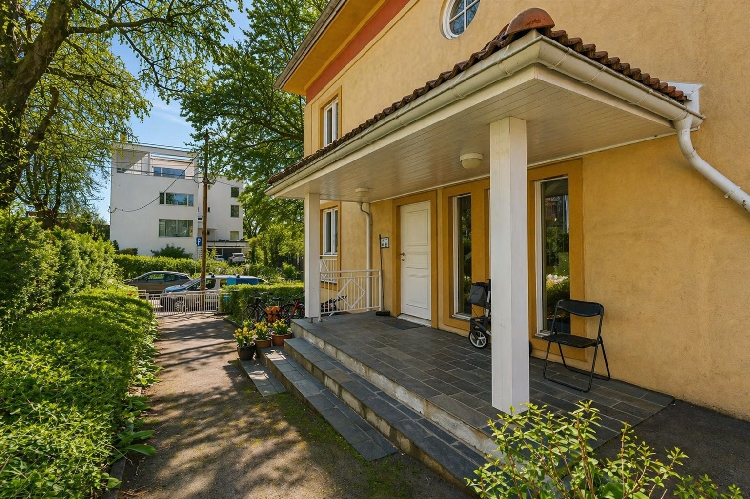 Hyggelig inngangsparti med varmekabler og frodig uteområde til glede for sameiets beboere. Galleribilde