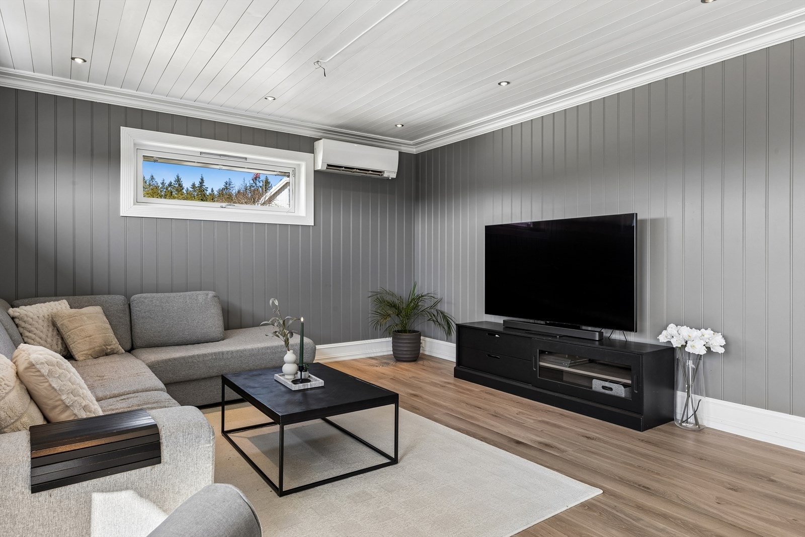 Stuen har en behagelig atmosfære med panel på veggene og downlights i taket. Galleribilde