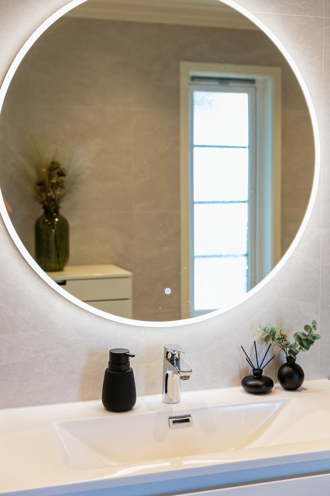 Detaljer som det runde speilet med LED-lys gir badet et moderne og eksklusivt preg. Galleribilde