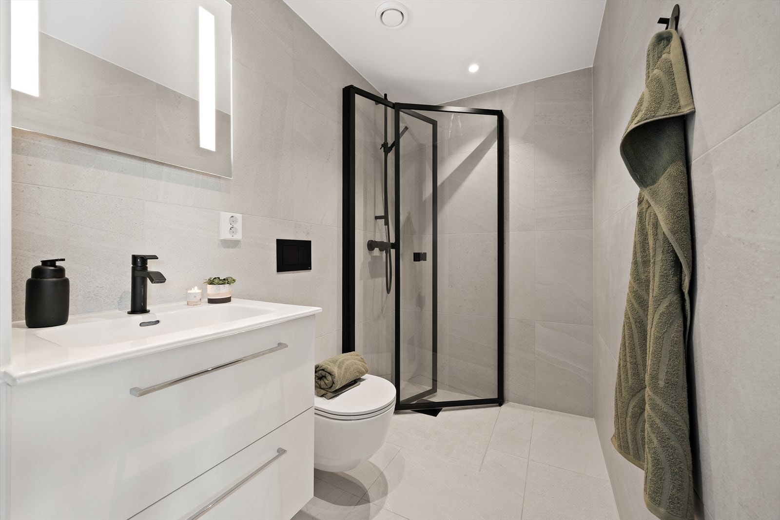 Badet i 1.etasje er utstyrt med servant med skuffeinnredning, ett-greps kran og speil med integrert belysning. Galleribilde