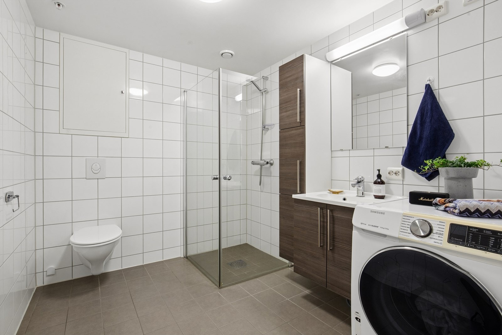 Badet er helfliset med vegghengt toalett og opplegg for vask/tørk Galleribilde