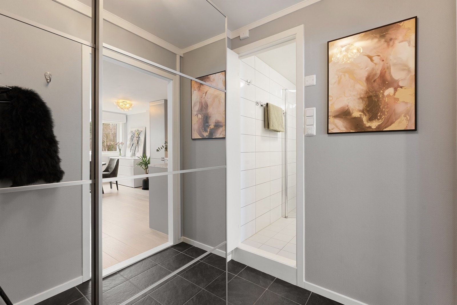 Fra entréen er det direkte tilgang til badet, og videre inn til leilighetens åpne oppholdsrom. Galleribilde