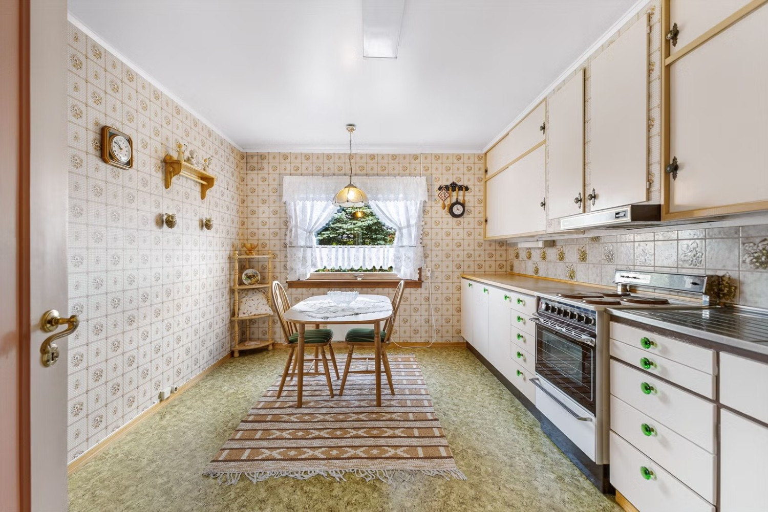Kjøkkeninnredningen består av et eldre kjøkken med lyse slette fronter, laminert benkeplate og beslagvask. Galleribilde